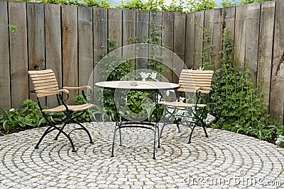 Garden patio with round table and two chairs. Outdoor furniture made of iron and wood material Stock Photo