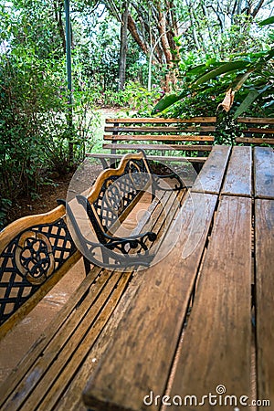 Garden patio table and bench chairs for a relaxing, peaceful outdoor dining and community backyard space Stock Photo