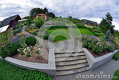 Garden plot with a house, flowerbeds and paving Stock Photo