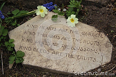 Garden poem on stone with primroses kindness concept Stock Photo