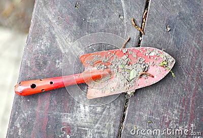 Garden red spade shovel close up photo with soil on the wooden bench Stock Photo