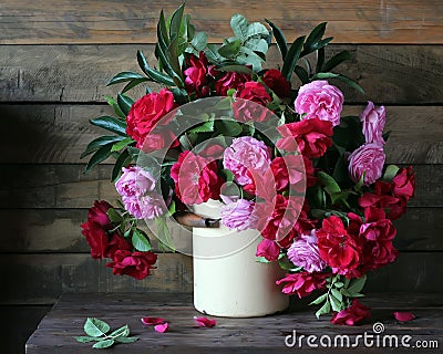 Garden roses in cans on the table. Stock Photo