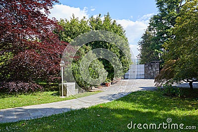 Garden with stone tiled path and court in a summer day, Italy Stock Photo