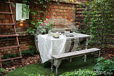 Garden in summer with patio, wooden garden furniture and barbecue. Dining table in backyard at home. Cozy space in patio or balcon Stock Photo