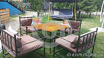 Garden table with iron chairs and a swing for relaxation Stock Photo