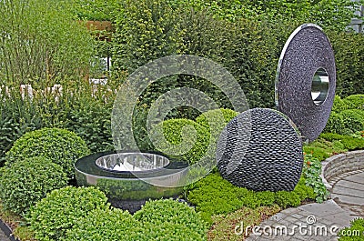 GARDEN WITH TOPIARY AND MODERN PEBBLE DECORATIVE CREATIONS Stock Photo