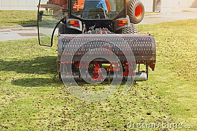 Gardener Operating Soil Aeration Machine on Grass Lawn Stock Photo