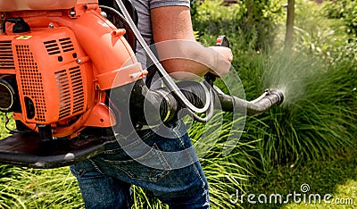 Gardener in protective mask and glasses spraying toxic pesticides trees Stock Photo
