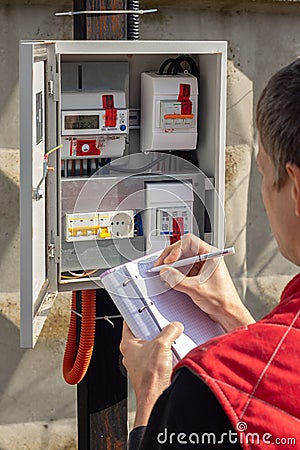 The gardener takes control readings of electricity meters Stock Photo