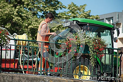 Gardener watering flowers on bridge Editorial Stock Photo