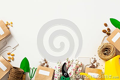 Gardeners supplies on white background. Flat lay paper bags of seeds, gardening shears, shovel, rake, watering can Stock Photo