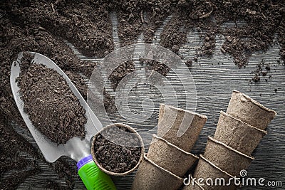 Gardening peat pots soil spade on wooden board Stock Photo