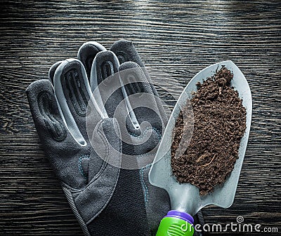 Gardening shovel soil safety gloves on wooden board Stock Photo