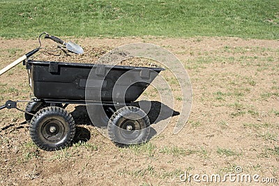 Gardening tools on pile of dirt and grasses in yard cart Stock Photo