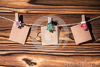 Garland with cute empty little kraft paper stickers hanging on a rope on wooden clothespins. Rustic Christmas decoration. Stock Photo