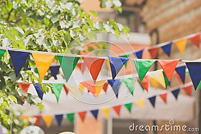 Garland decoration at the fair. Decorations of colorful pennants and colorful flag of the festival. Strings with flags Stock Photo