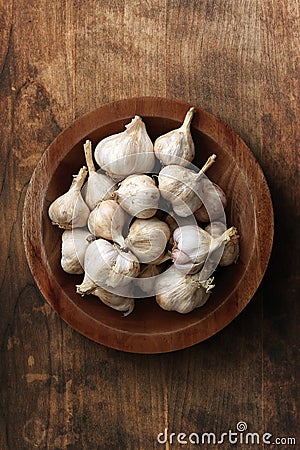 Garlic cloves in wooden plate Stock Photo