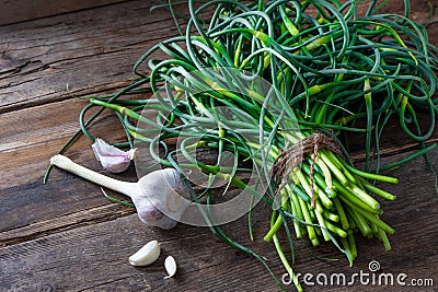 Garlic arrows. A bunch of greens on the table. Vegetable healthy vitamin food. Green stalks seedlings for salad and Stock Photo