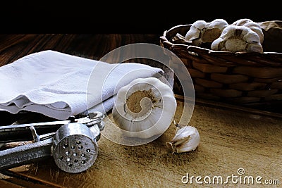 Garlic basket, garlic bulb and garlic press on wooden cutting board, Vintage effect photo treatment Stock Photo