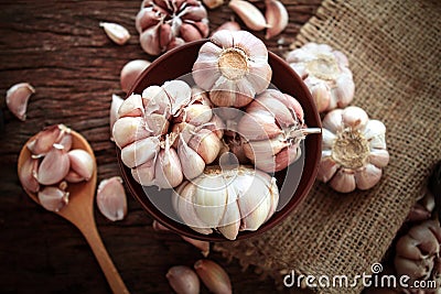 Garlic bulb in bowl on wooden table , top overhead shot Stock Photo
