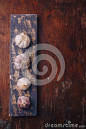 Garlic bulbs on wooden boards background. Natural antioxidant, anticoagulant, spicy vegetable, flavouring. Copy space, vertical Stock Photo