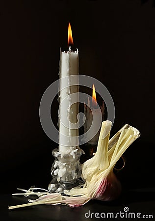 Garlic and burning candles Stock Photo