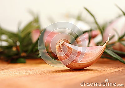 Garlic clove with fresh rosemary in background Stock Photo