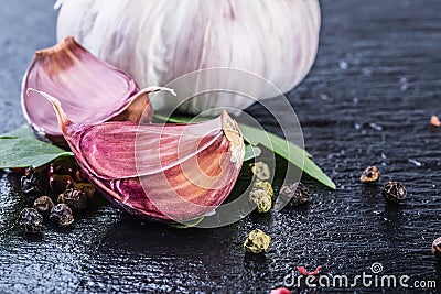 Garlic. Fresh Garlic. Cloves of garlic with parsley herb top leaves and pepper four colours Stock Photo