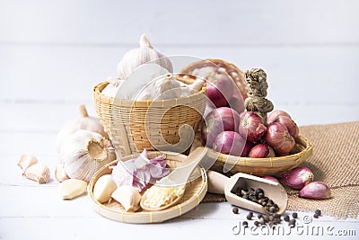 Garlic,shallot,Black pepper, fresh garlic, garlic clove, garlic bulb and shallot in a wooden basket on white wooden table, A herb Stock Photo