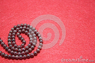 Garnet beads on a red felt background Stock Photo