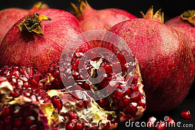 Garnet fruits and pulp on black background. Fresh pomegranate fruits and seeds close up. Stock Photo