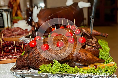 Garnished roasted turkey on holiday table decorated tomatoes Stock Photo