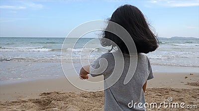 Garotinha asiática brincando na praia com a costa da onda marinha natural para o conceito de férias de verão filme Garotinha asiática brincando na praia com a costa da onda marinha natural para o conceito de férias de verão filme