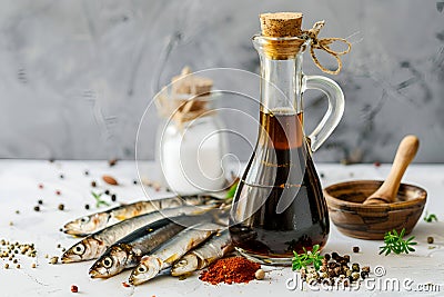 Garum fish sauce in a decanter on the table with fresh sardines and spices. Stock Photo