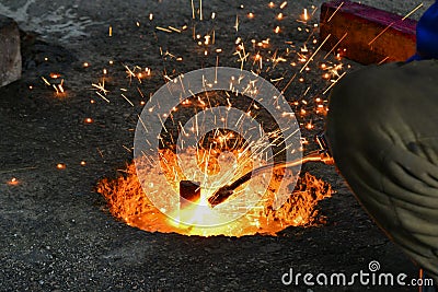 A gas cutter in production, a welder removes unnecessary metal residues with a gas cutter, sparks fly in different directions Stock Photo