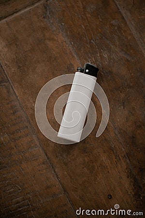 A gas-fueled lighter against a wooden table as a background Stock Photo