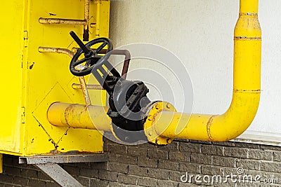 Gas pipe on the facade of an apartment building. A valve for shutting off the supply of energy resources in the event of an Stock Photo