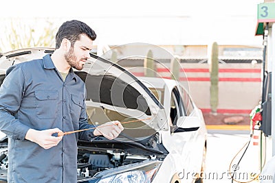 Gas Station Attendant Checking Engine Oil Stock Photo