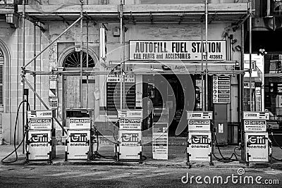 Gas station featuring a variety of pumps and vintage-style posters advertising fuel products. Editorial Stock Photo