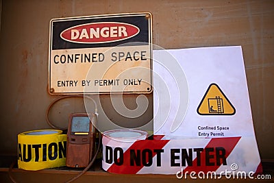 Gas test leak atmosphere confined space warning sign permit entry by permit only and red barricade danger tape Stock Photo