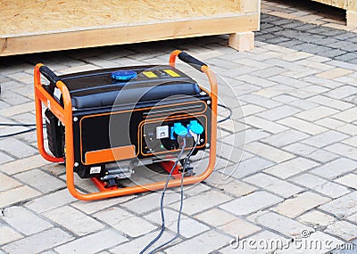 Gasoline Portable Generator on the House Construction Site. Close up on Mobile Backup Generator. Standby Generator Stock Photo