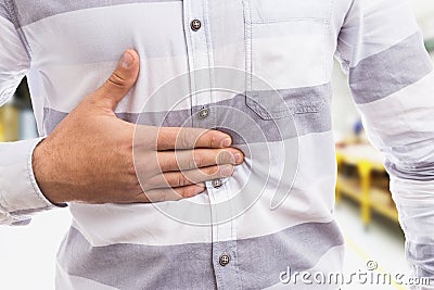 Gastric acid concept with man pressing his stomach Stock Photo