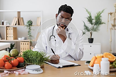 Gastroenterologist writing diet plan on clipboard paper Stock Photo