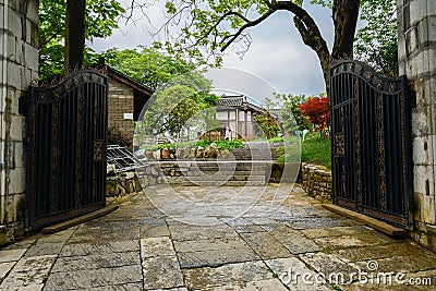 Gate of enclosed old-fashioned buildings in cloudy spring after Stock Photo