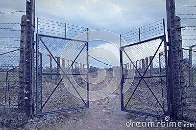 Gate to the concentration camp auschwitz-birkenau. Barbed wire fence around the death camp in Oswiecim. He assumes people during t Editorial Stock Photo