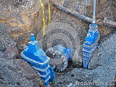 Gate valves in a dug trench in a pavement - part of a water supply network in the UK Editorial Stock Photo