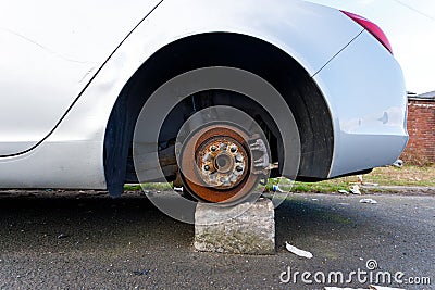 A broken down car with wheels removed on bricks Stock Photo