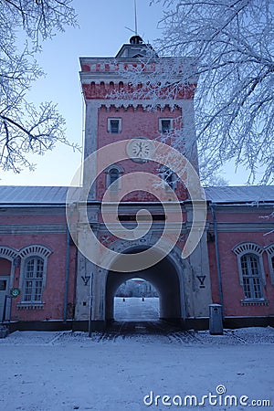 Gateway to Suomenlinna fortress island via historical jetty barracks and clock tower on cold winter morning. Editorial Stock Photo