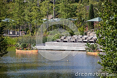 The Gathering Place - Award winning public park in Tulsa OK USA - Wooden deck with chairs beside pond with rowboats filled with Stock Photo