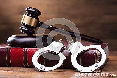 Gavel And Handcuffs On Law Book Stock Photo
